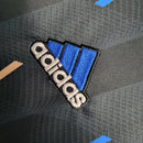 Camisa Manchester United Pré-jogo 23/24 - Torcedor Adidas Masculina - Preto com detalhes em azul e rosa